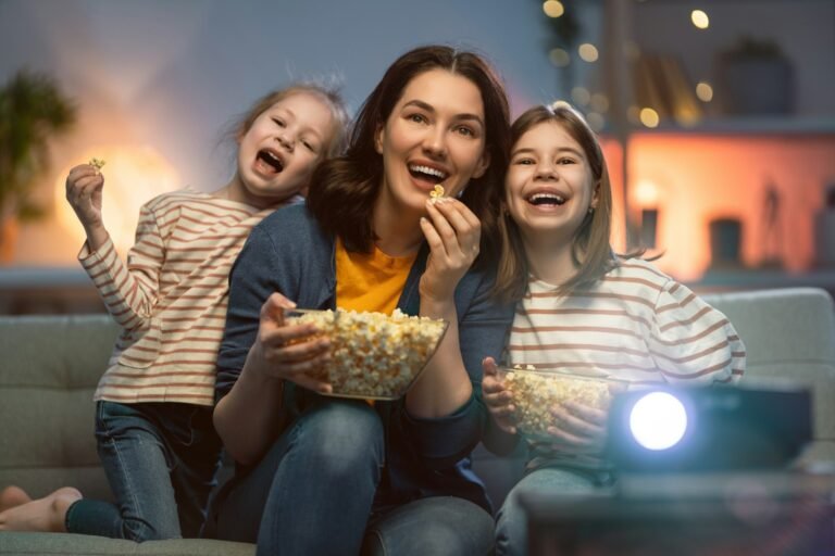 Mamá y dos niños viendo una película en casa con palomitas