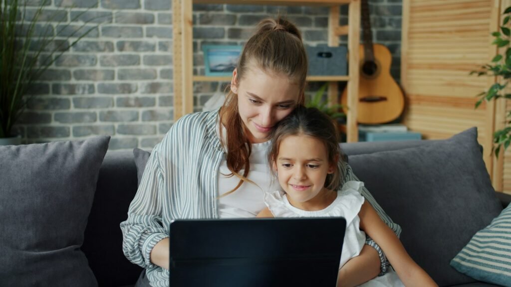 Madre e hija mirando juntas una laptop en casa